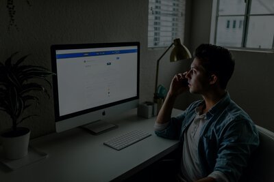 a guy making a call while staring at his desktop